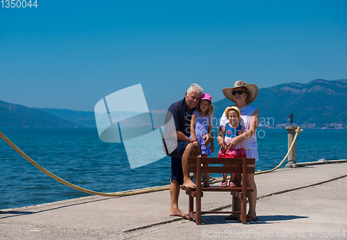 Image of portrait of grandparents and granddaughters by the sea