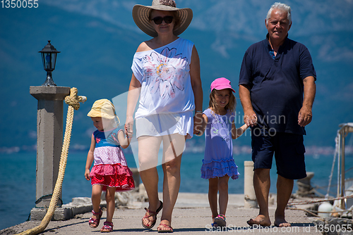 Image of grandparents and granddaughters walking by the sea
