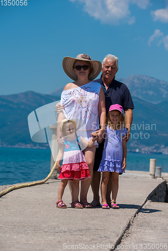 Image of portrait of grandparents and granddaughters standing by the sea