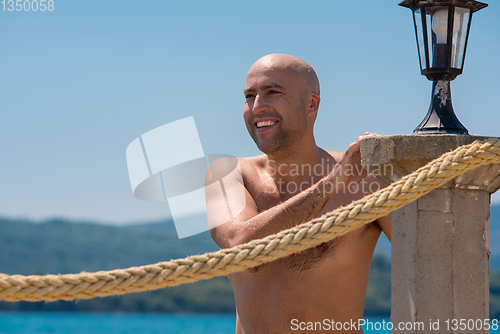 Image of man with naked torso by the sea