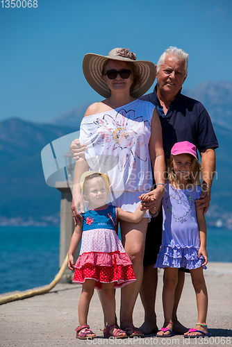 Image of portrait of grandparents and granddaughters standing by the sea