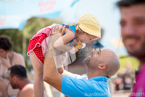 Image of cute little girl eating ice cream with her young father