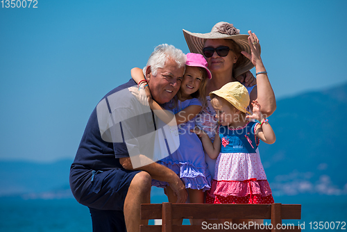 Image of portrait of grandparents and granddaughters by the sea