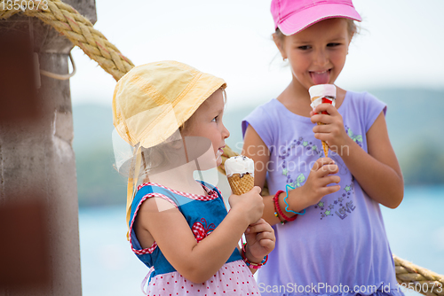 Image of little girls eating ice cream by the sea