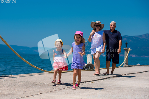 Image of grandparents and granddaughters walking by the sea