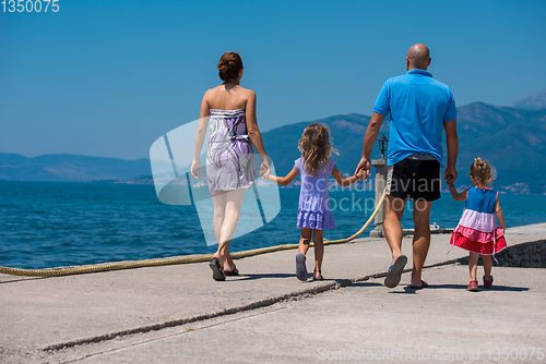 Image of young happy family walking by the sea