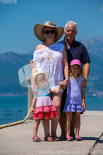 Image of portrait of grandparents and granddaughters standing by the sea