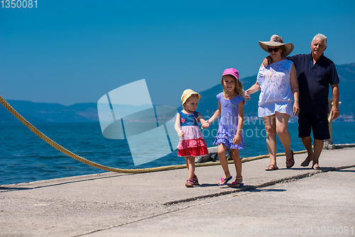 Image of grandparents and granddaughters walking by the sea