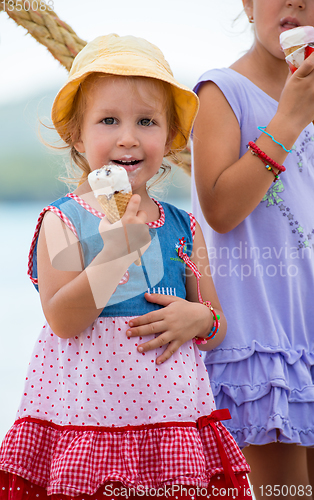 Image of little girls eating ice cream by the sea