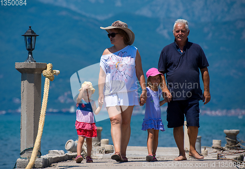 Image of grandparents and granddaughters walking by the sea