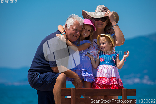 Image of portrait of grandparents and granddaughters by the sea