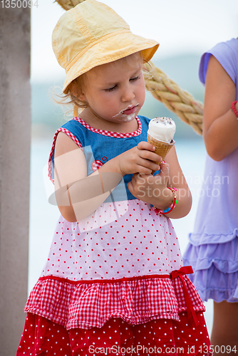 Image of little girls eating ice cream by the sea