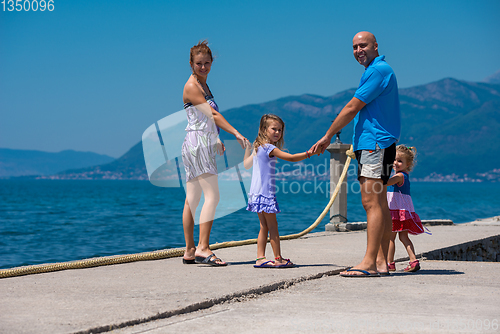 Image of young happy family walking by the sea