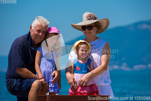 Image of portrait of grandparents and granddaughters by the sea