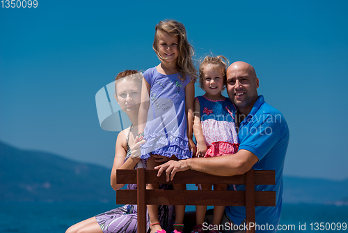 Image of portrait of young happy family with daughters by the sea