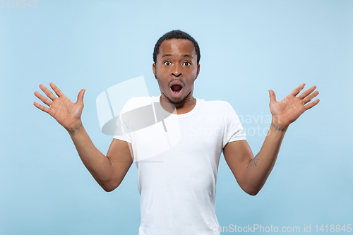 Image of Half-length close up portrait of young man on blue background.