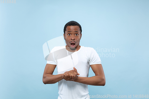 Image of Half-length close up portrait of young man on blue background.
