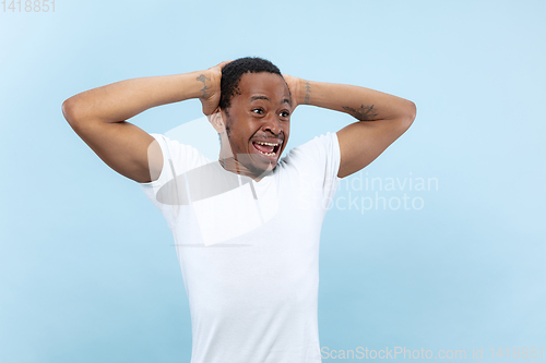 Image of Half-length close up portrait of young man on blue background.
