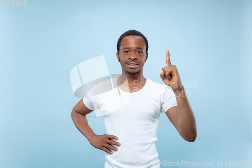 Image of Half-length close up portrait of young man on blue background.