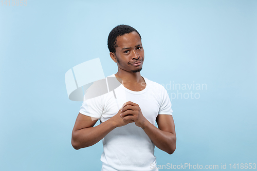 Image of Half-length close up portrait of young man on blue background.