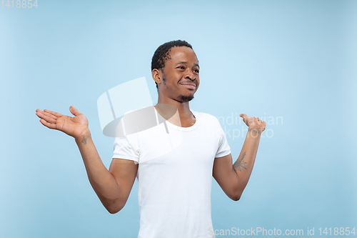 Image of Half-length close up portrait of young man on blue background.