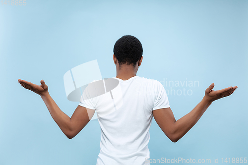 Image of Half-length close up portrait of young man on blue background.