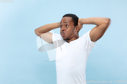 Image of Half-length close up portrait of young man on blue background.