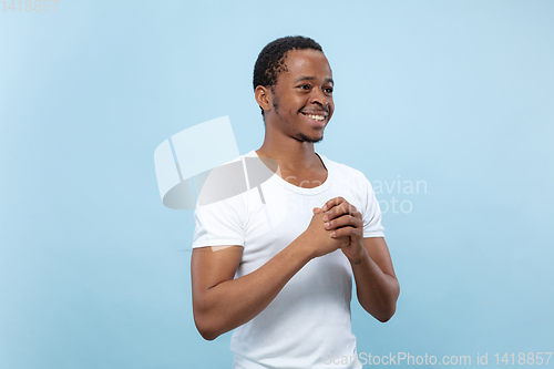 Image of Half-length close up portrait of young man on blue background.