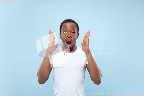 Image of Half-length close up portrait of young man on blue background.