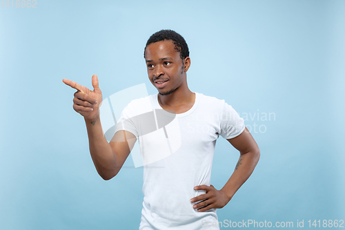 Image of Half-length close up portrait of young man on blue background.