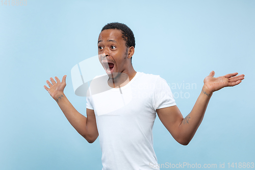 Image of Half-length close up portrait of young man on blue background.