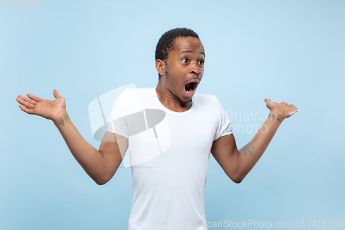 Image of Half-length close up portrait of young man on blue background.