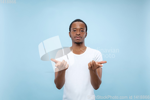 Image of Half-length close up portrait of young man on blue background.