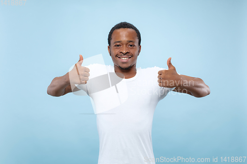 Image of Half-length close up portrait of young man on blue background.