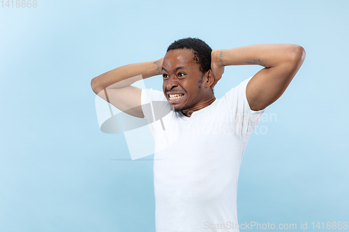 Image of Half-length close up portrait of young man on blue background.