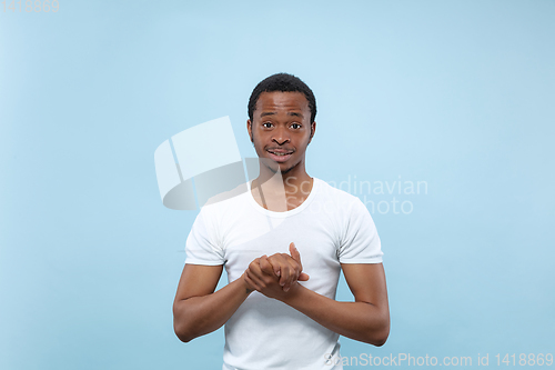 Image of Half-length close up portrait of young man on blue background.