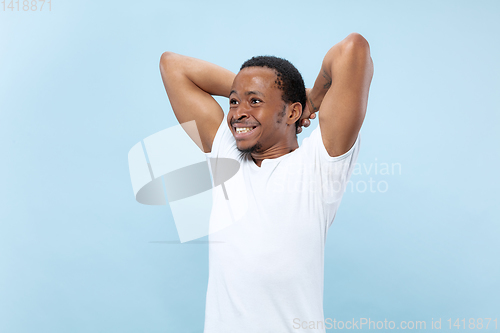 Image of Half-length close up portrait of young man on blue background.