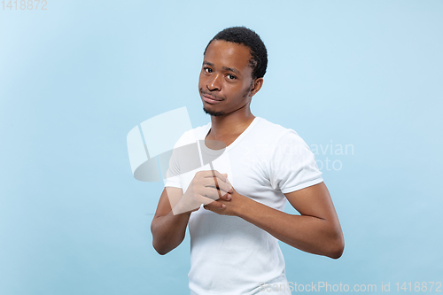 Image of Half-length close up portrait of young man on blue background.