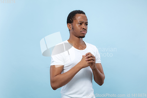 Image of Half-length close up portrait of young man on blue background.