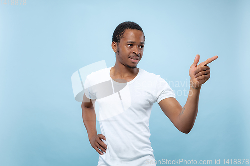 Image of Half-length close up portrait of young man on blue background.