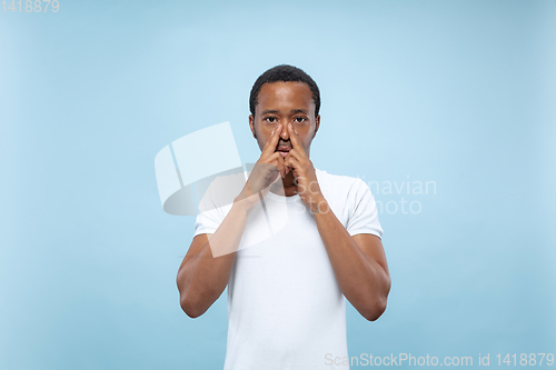 Image of Half-length close up portrait of young man on blue background.