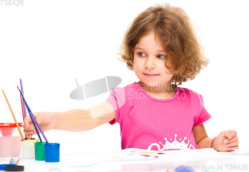 Image of Little girl is painting with gouache