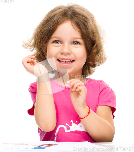 Image of Little girl is painting with gouache