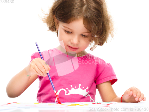 Image of Little girl is painting with gouache