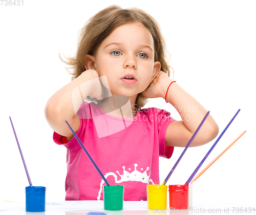 Image of Little girl is painting with gouache