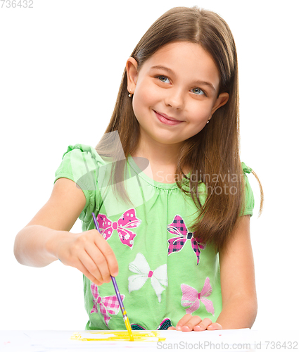 Image of Little girl is painting with gouache