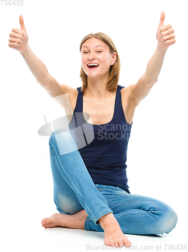 Image of Young happy woman is showing thumb up sign