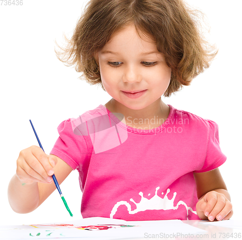 Image of Little girl is painting with gouache