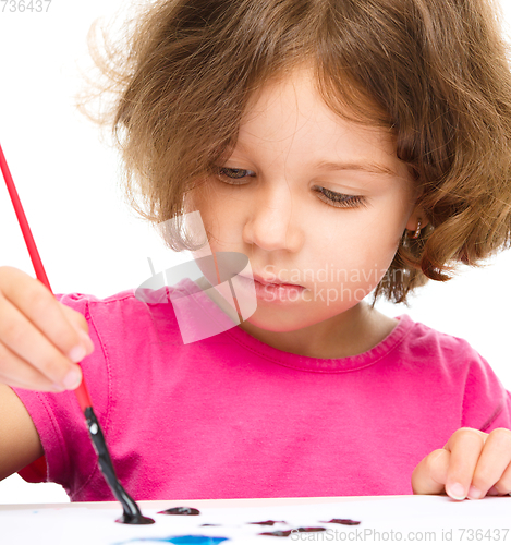 Image of Little girl is painting with gouache