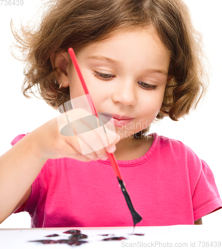 Image of Little girl is painting with gouache